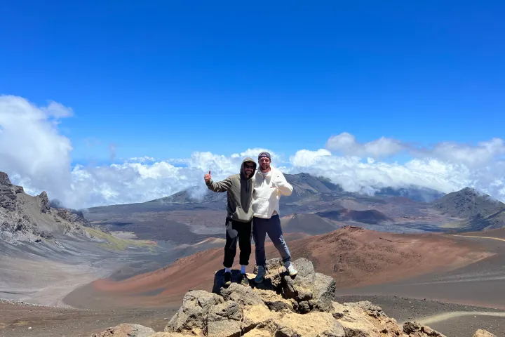 two men standing on top of a mountain