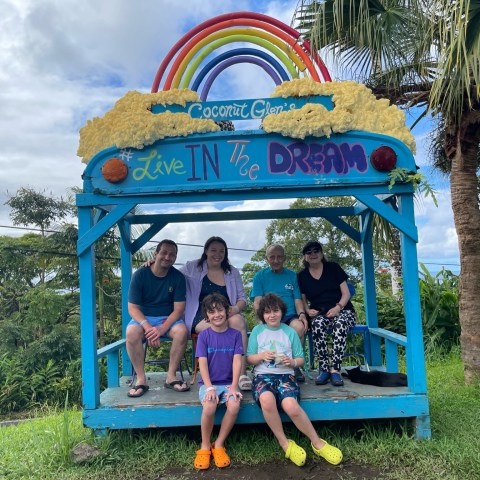 a group of people sitting on a bench posing for the camera