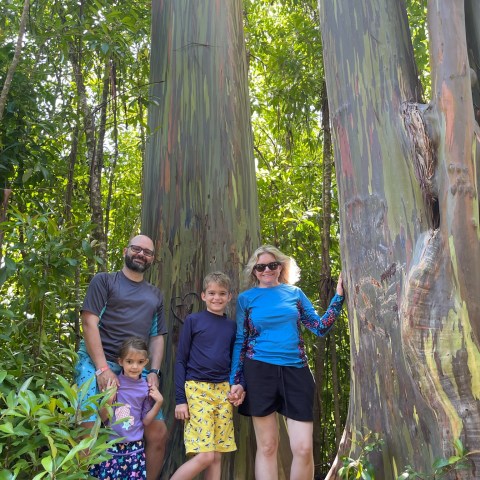 a group of people standing in front of a tree