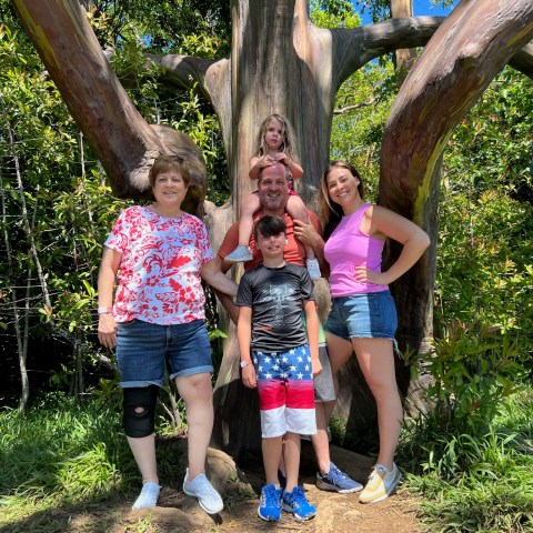 a group of people standing next to a tree