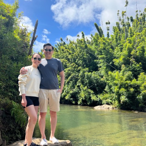 a man and a woman standing next to a tree