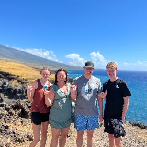 a group of people standing on a beach posing for the camera