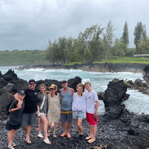 a group of people standing on a rocky beach