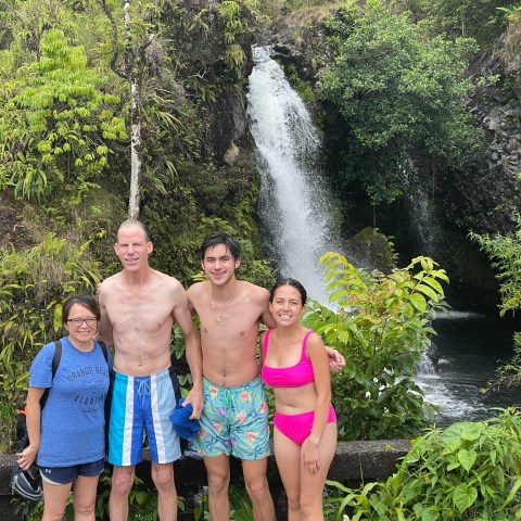a group of people standing in front of a tree posing for the camera