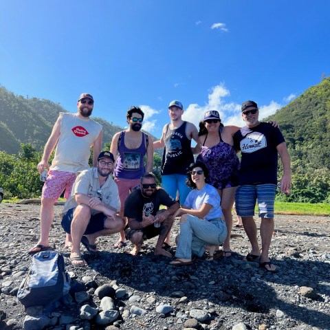 a group of people standing on a rocky beach