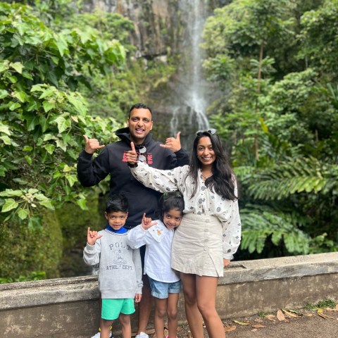 a little girl standing next to a tree