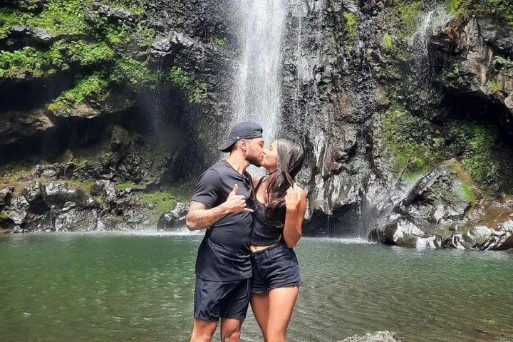 a man standing next to a waterfall