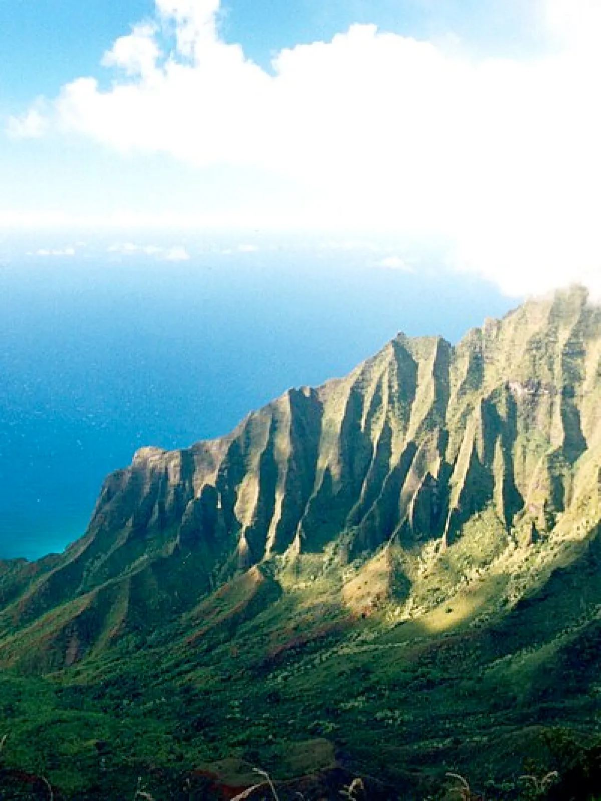 Na_Pali_Coast,_Kauai,_Hawaii a view of a large mountain in the background