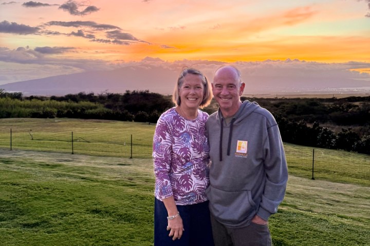a man standing on top of a grass covered field